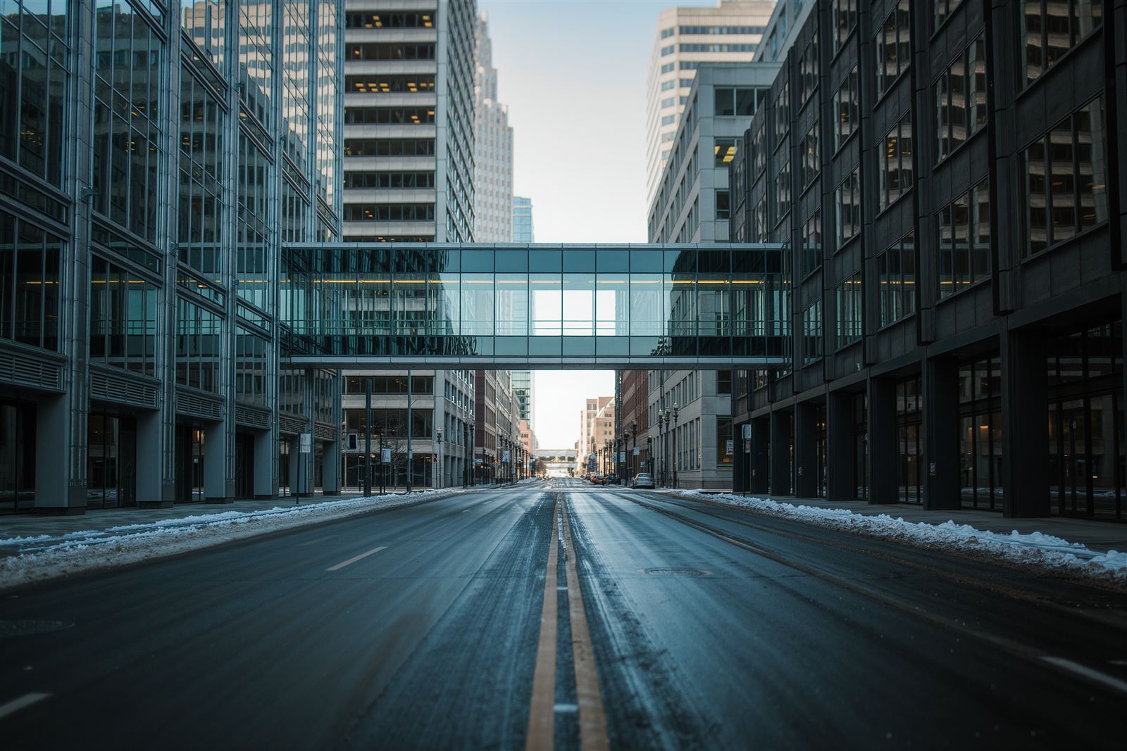 Downtown Minneapolis glass towers with a skyway bridge over a snowy street