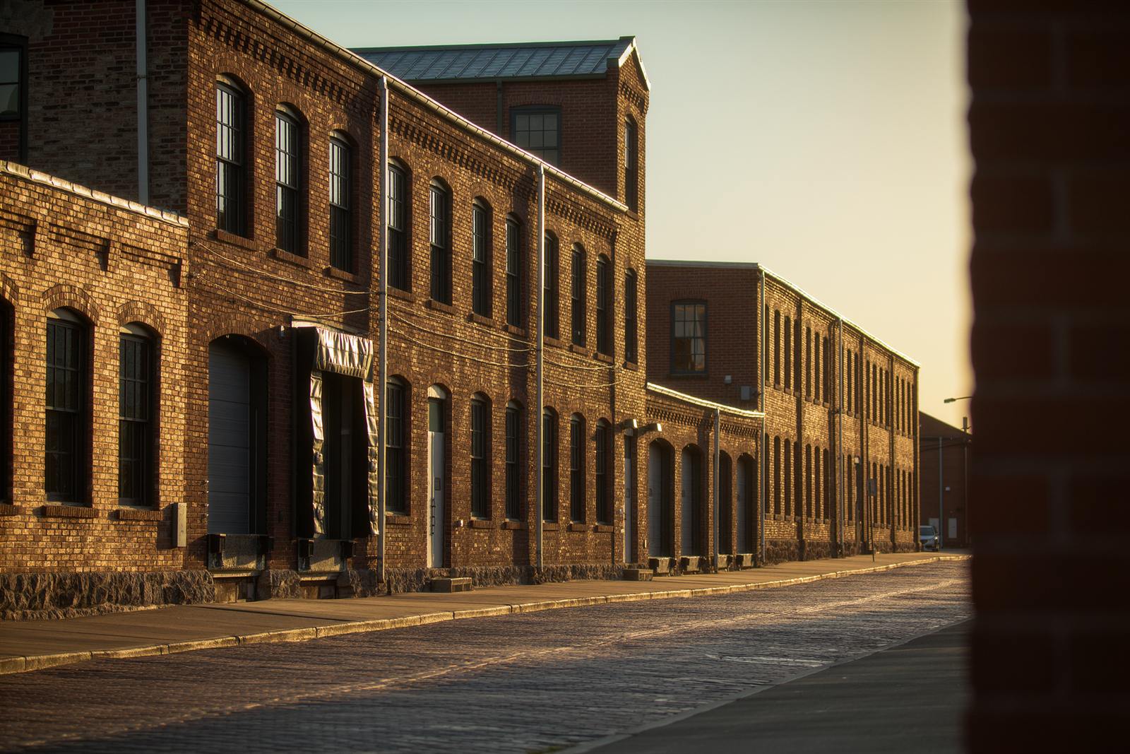 Converted brick warehouse buildings with arched windows on a brick street in the North Loop